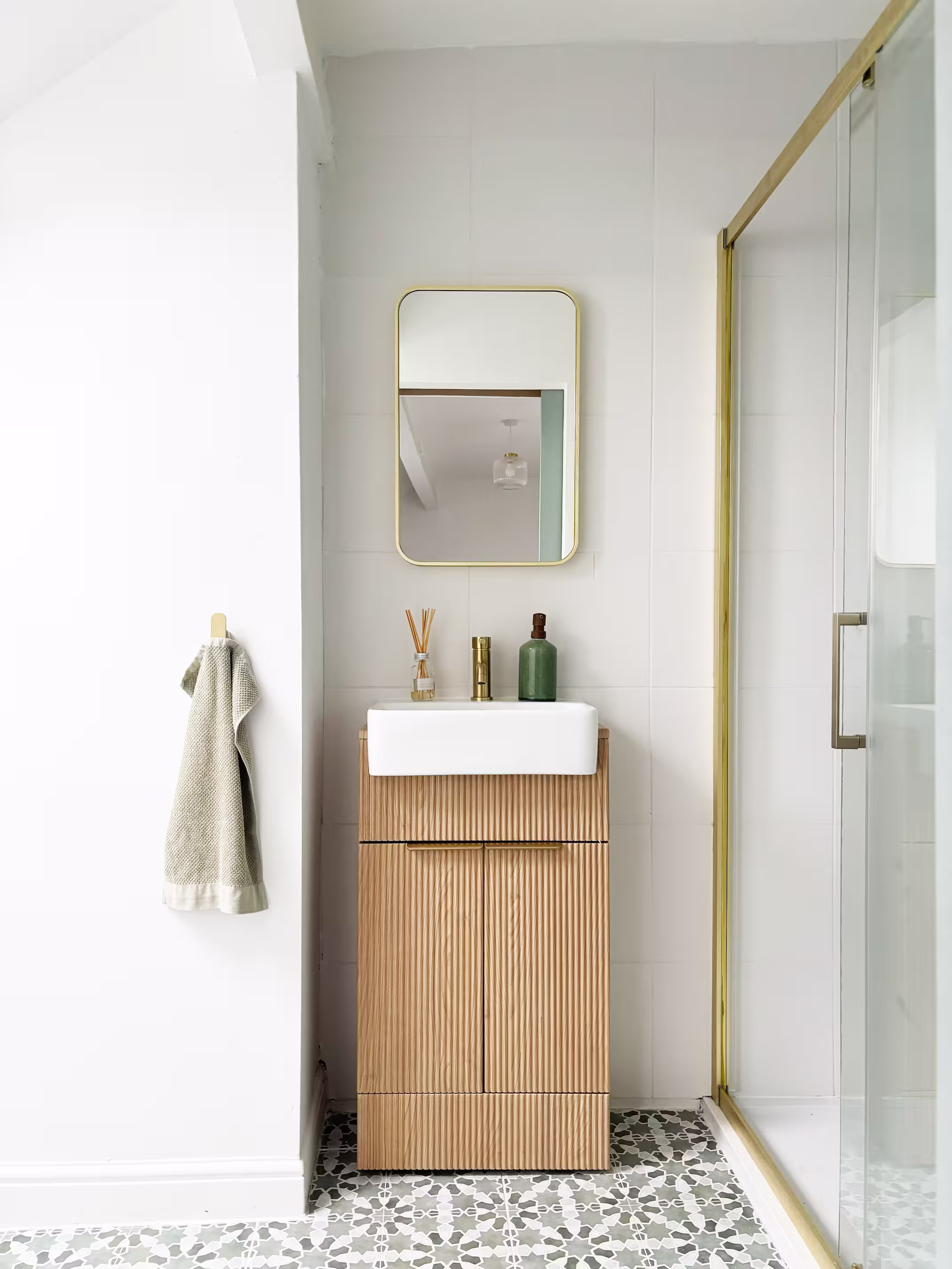 Contemporary bathroom with wooden vanity unit, brass framed shower screen and patterned tile floor in renovated Pudsey terrace house
