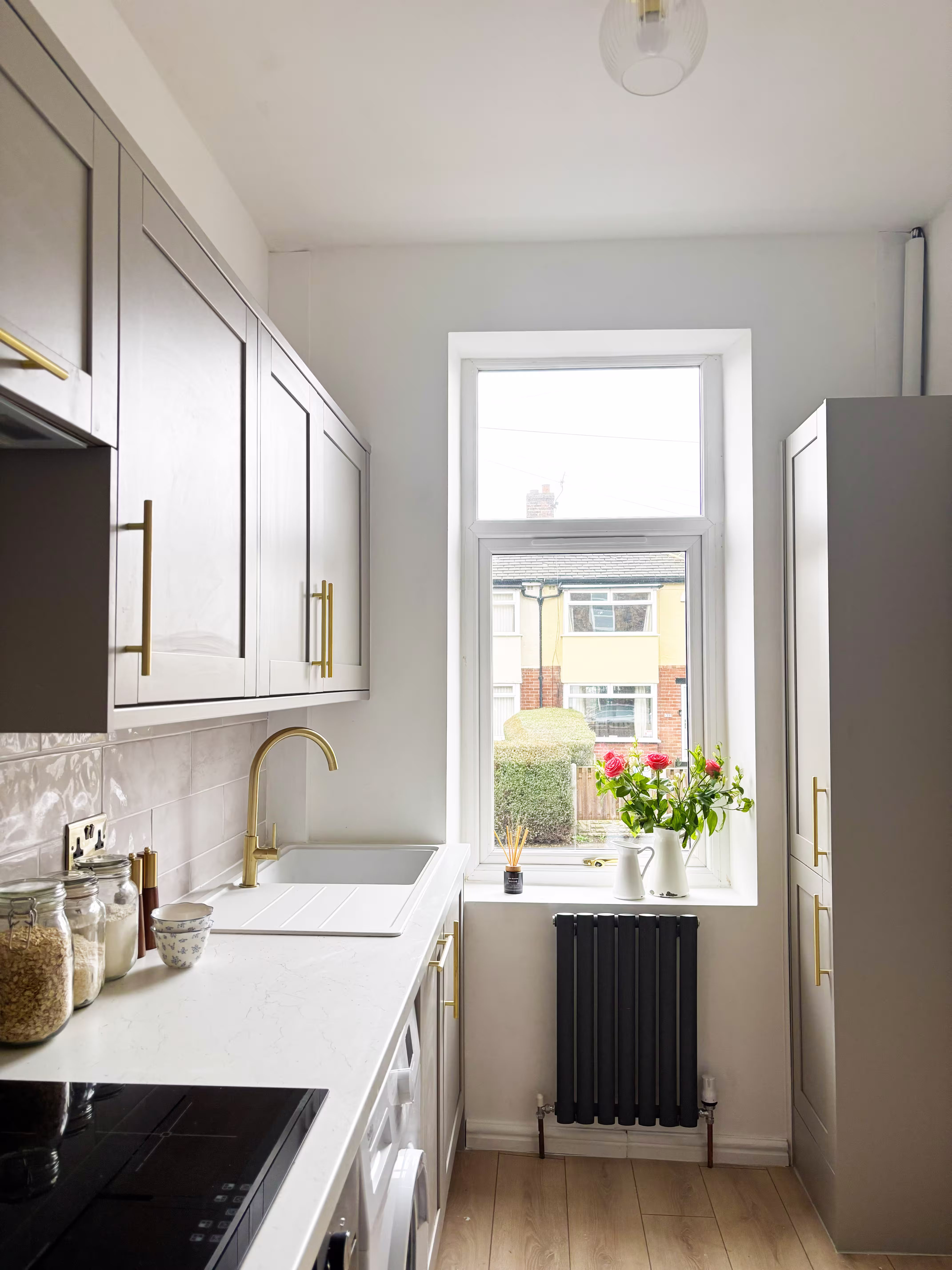 Narrow galley kitchen renovation with shaker cabinets, quartz worktops and brass fittings in a Pudsey terrace property