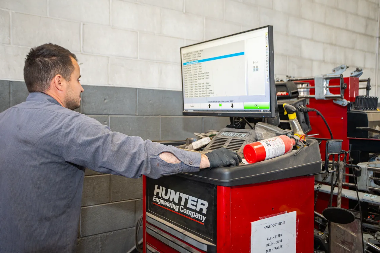 Technician runs full diagnostics on a Hunter system, selecting vehicle specs from a list on the screen.