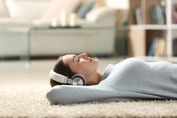 Participant practicing guided body scan meditation with headphones to support relaxation and stress reduction.
