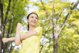 A woman in the forest exercising as a means of practicing indfulness movement in order to reduce anxiety and be more present 