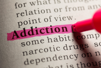 The word "Addiction" is highlighted in pink on a dictionary page. The definition includes phrases like "some habit" and "narcotic drugs."