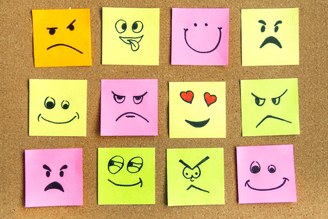 Twelve sticky notes arranged in a 3x4 grid, each featuring a different hand-drawn emoji face expressing various emotions like anger, happiness, and love