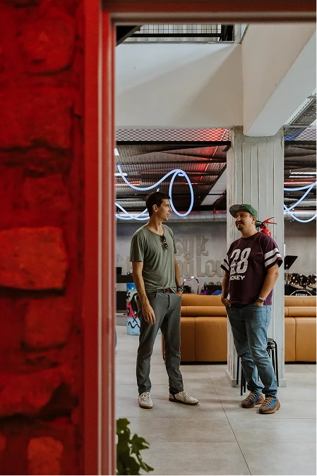 Two people having a conversation in a lounge area with colorful neon lighting