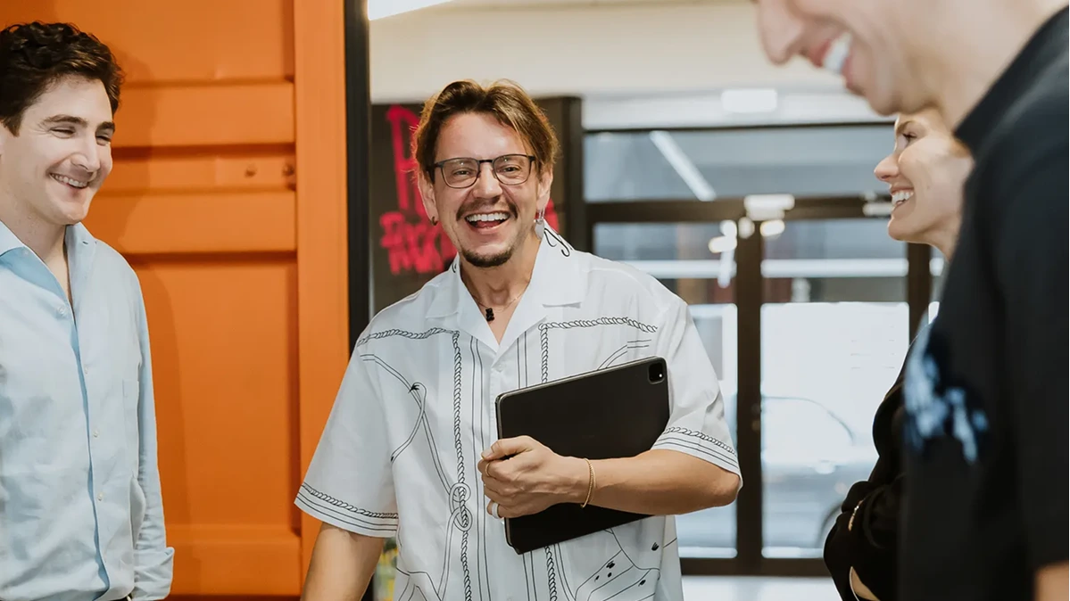 Group sharing a laugh together in an office hallway