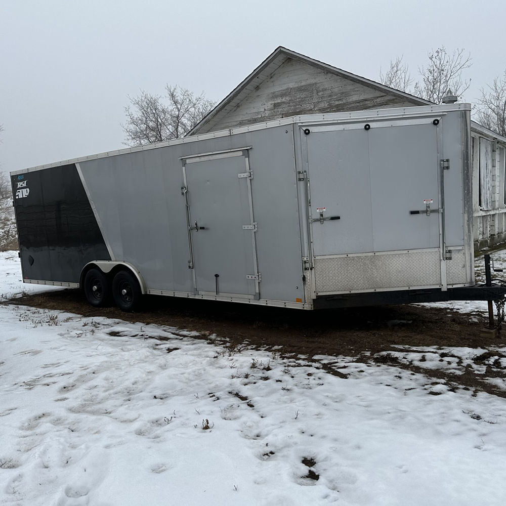Drive‑through enclosed trailer with dual access doors, enclosed cargo space, and secure design for hauling equipment and materials.