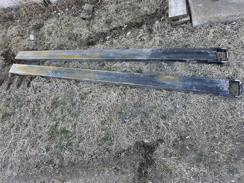 Heavy‑duty pallet forks attachment for skid steers, designed for lifting and transporting pallets and materials.
