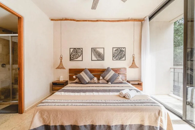 View of Modern Bedroom at Sands Tulum, showcasing Natural Light, Wood Headboard.