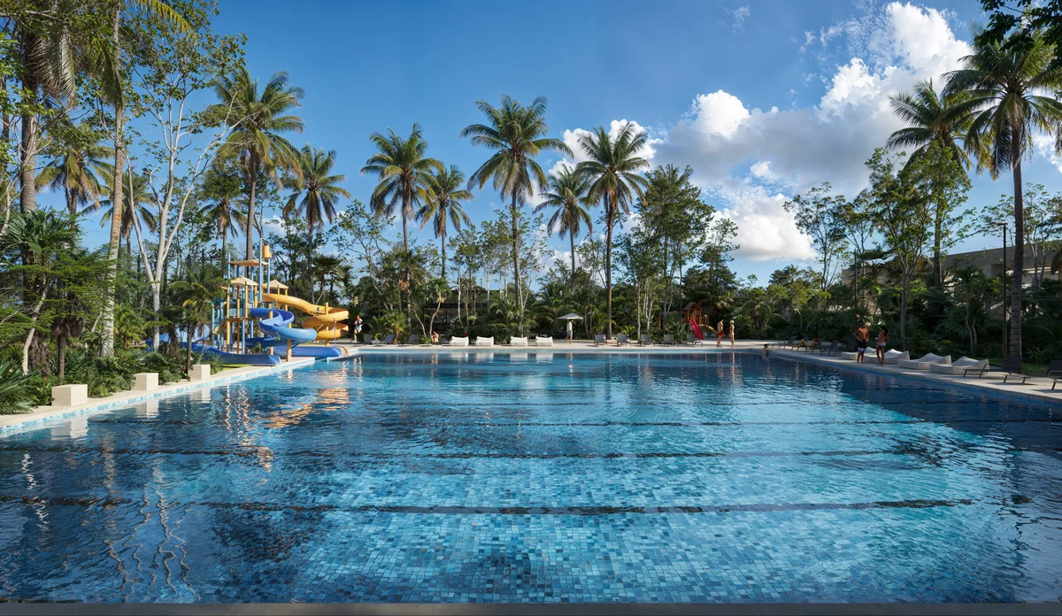 Image of a Resort-Style Pool, featuring Tropical Landscaping and Palm Trees.