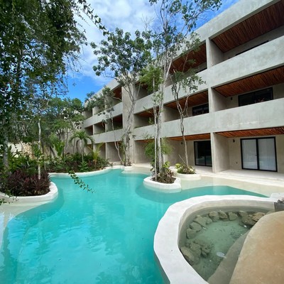 Image of a Lagoon-style Pool, featuring Modern Concrete Architecture and Lush Tropical Landscaping.