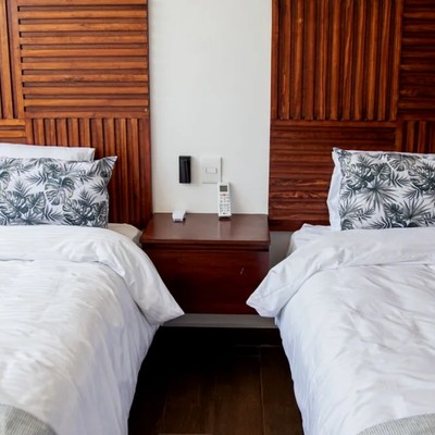 Image of a Twin Bedroom, featuring Custom Wooden Headboards and Slatted Wood Design.
