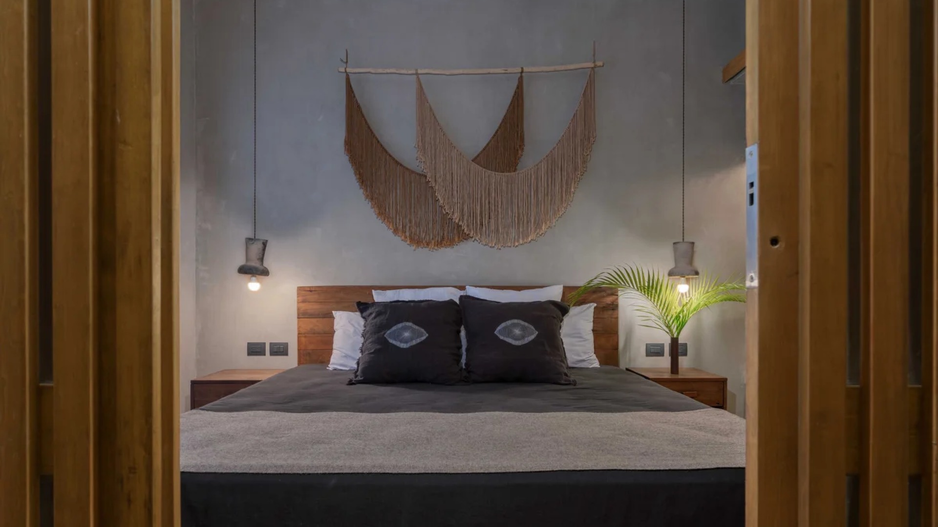 Image of a Stylish Bedroom, featuring Concrete-Finish Walls and Boho-Chic Decor.