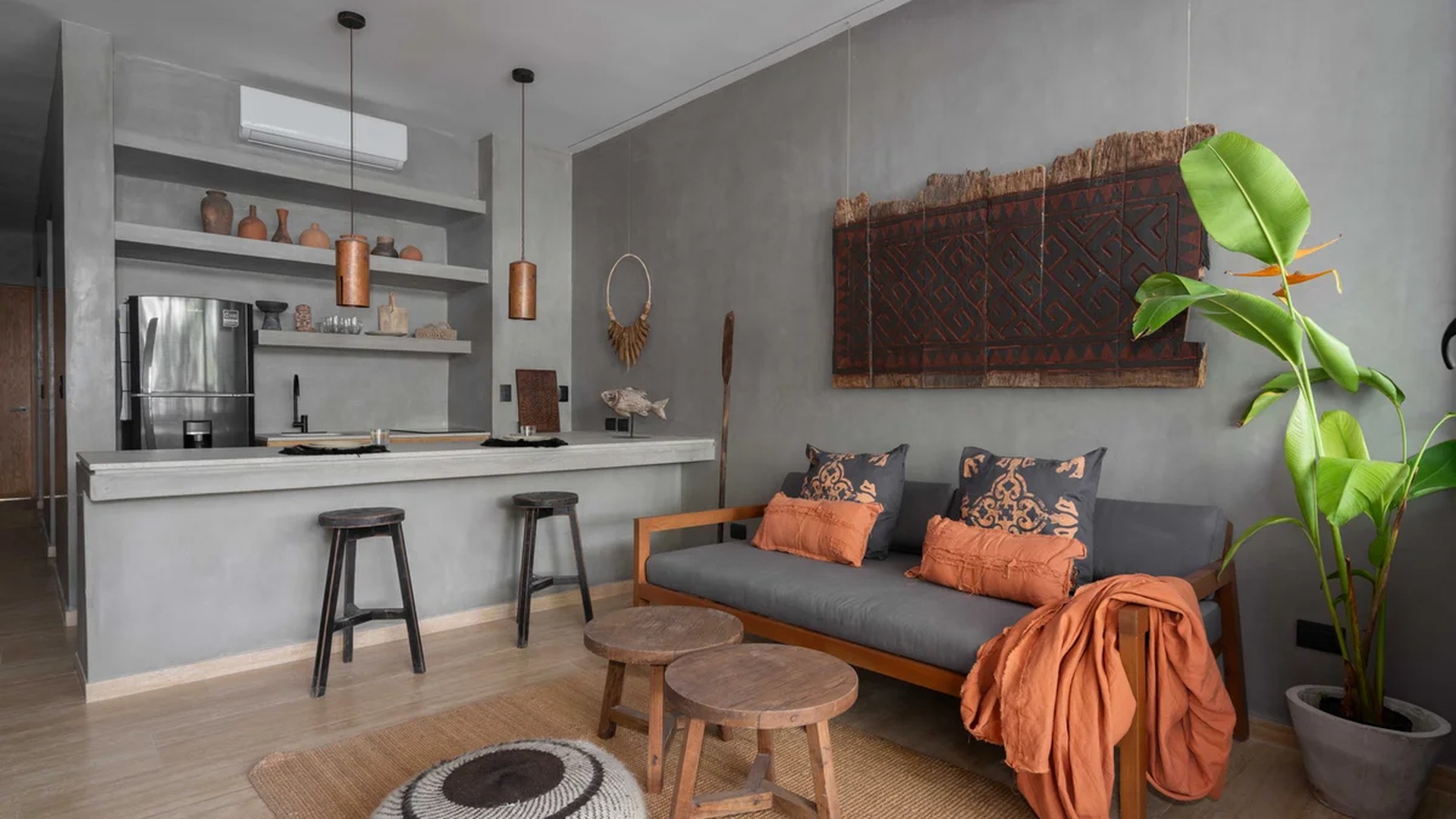 Image of a Open-Plan Living Area, featuring Polished Concrete Walls and Kitchen with Breakfast Bar.