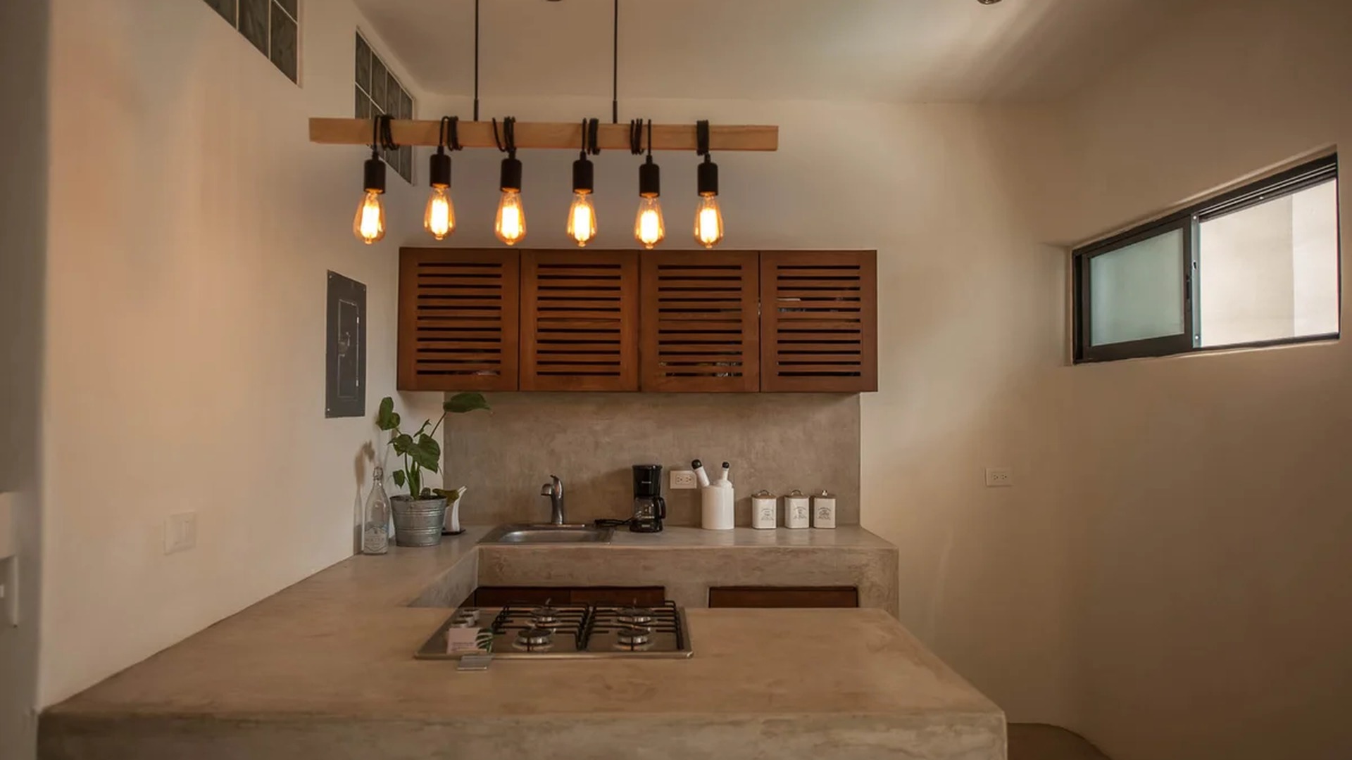 Image of a Kitchenette, featuring Concrete Countertops and Industrial Style Lighting.
