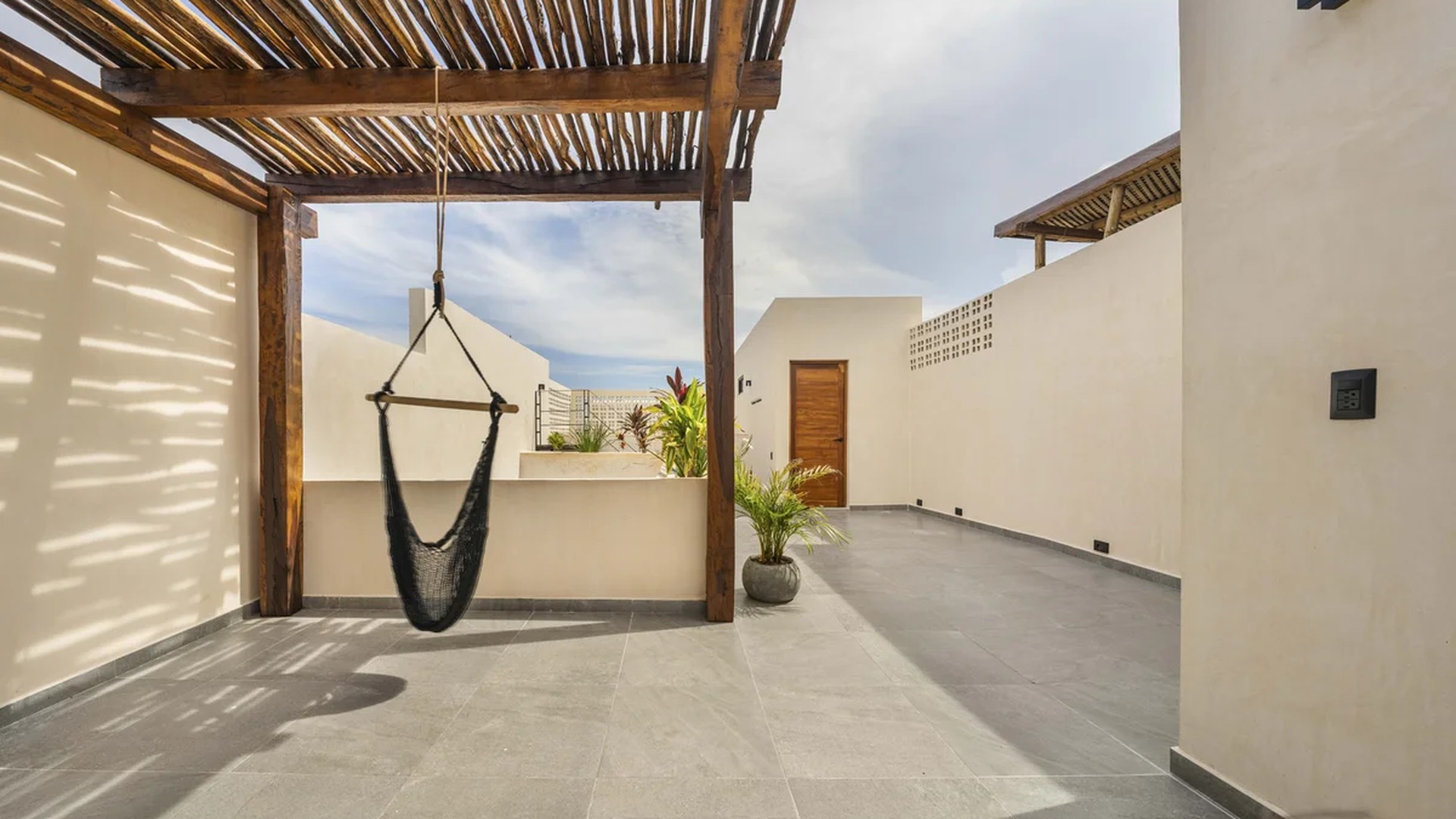 Image of a Rooftop Terrace, featuring Wooden Pergola and Outdoor Living Space.