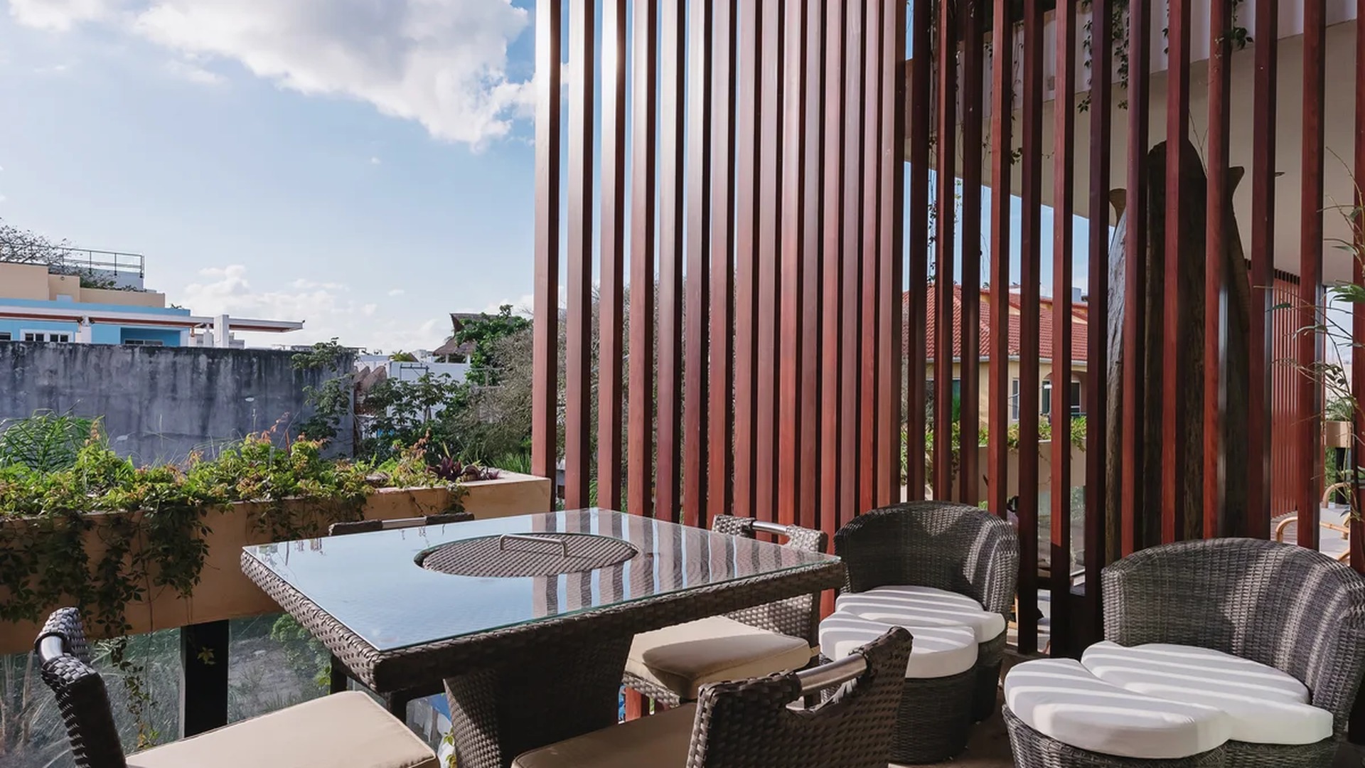 Image of a Covered Balcony, featuring Outdoor Seating Area and Architectural Slat Wall.