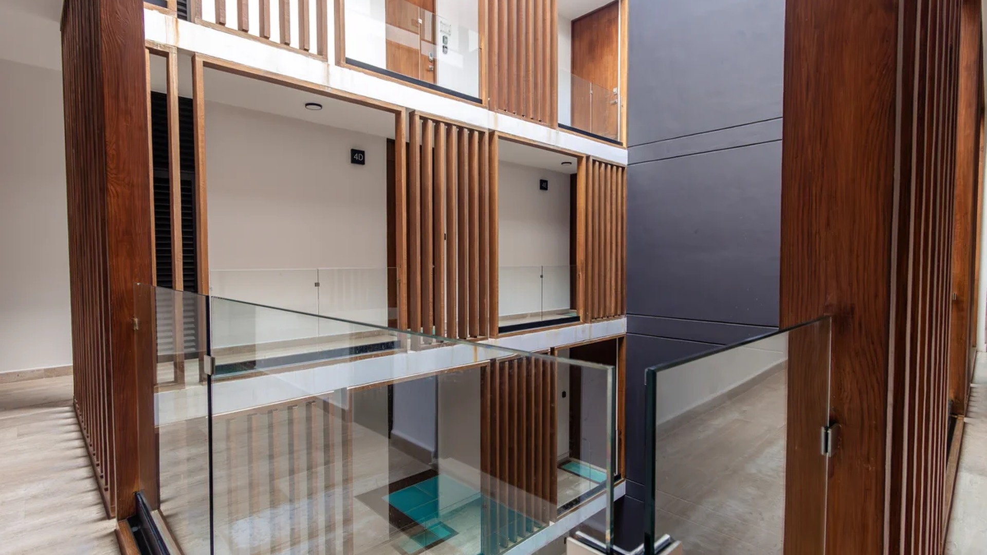 Image of a Modern Apartment Building, featuring Open-Air Atrium and Wooden Slat Design.