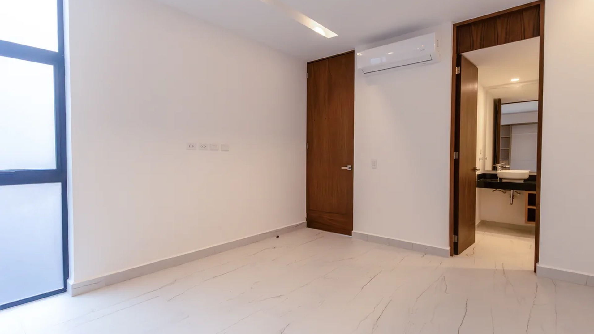 Image of a Spacious Bedroom, featuring En-suite Bathroom and Porcelain Tile Flooring.