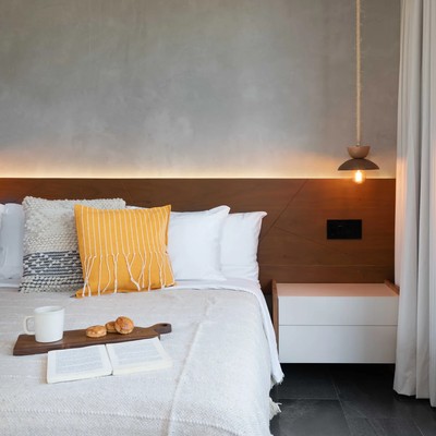 Image of a Modern Bedroom, featuring Concrete Accent Wall and Backlit Wooden Headboard.