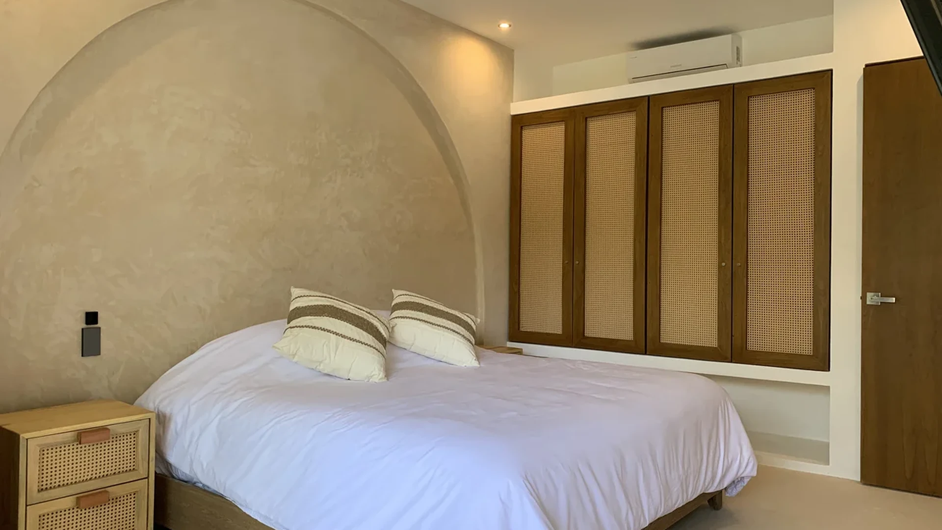 Image of a Primary Bedroom, featuring Textured Plaster Walls and Arched Headboard Feature.