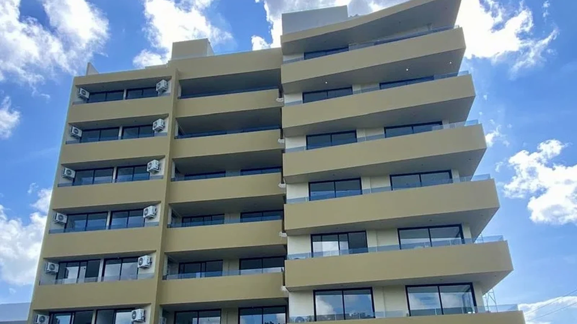 Image of a Modern Apartment Building, featuring Private Balconies and Glass Railings.