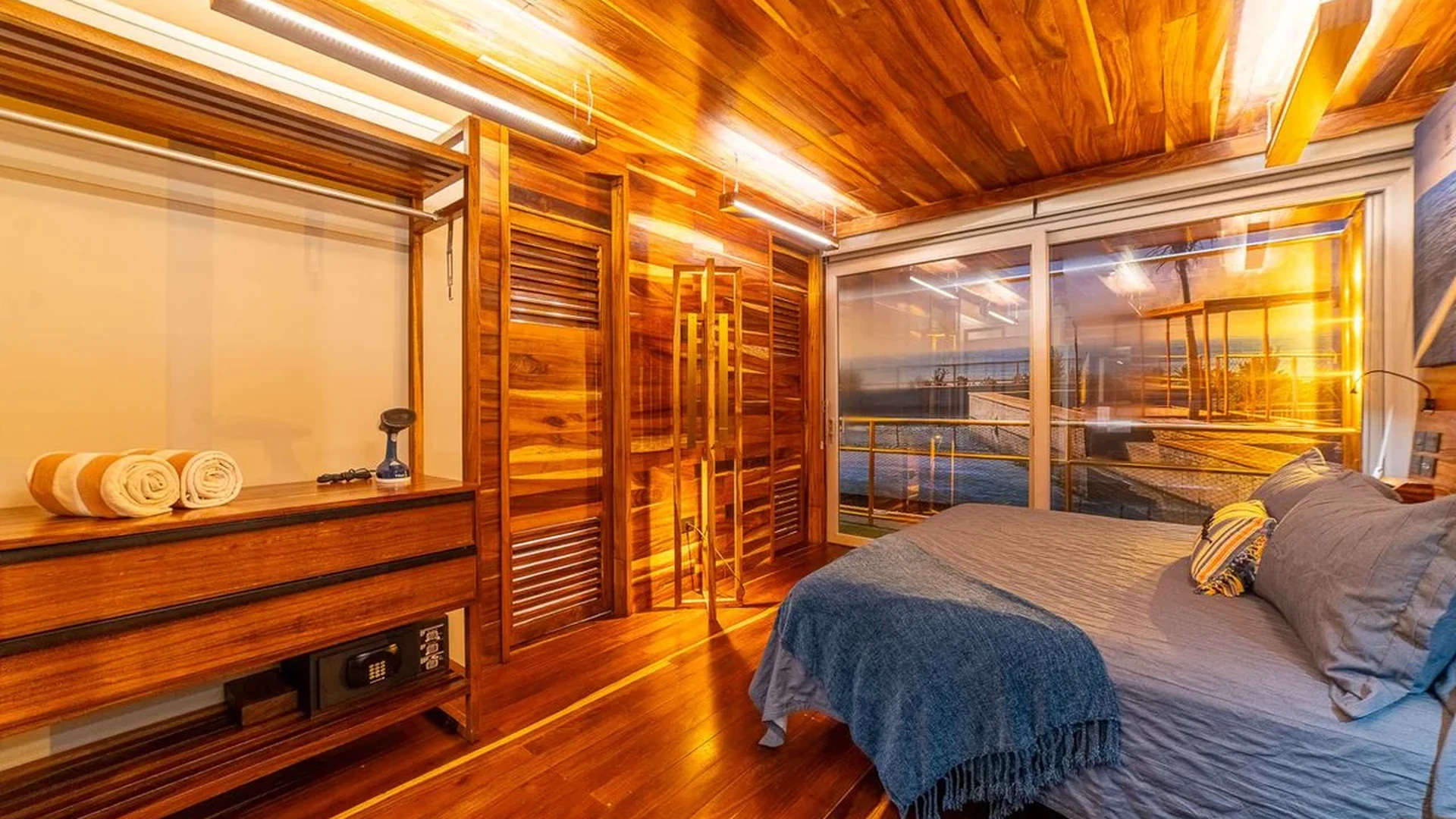 Image of a Bedroom with Ocean View, featuring Wood-Paneled Interior and Hardwood Floors.