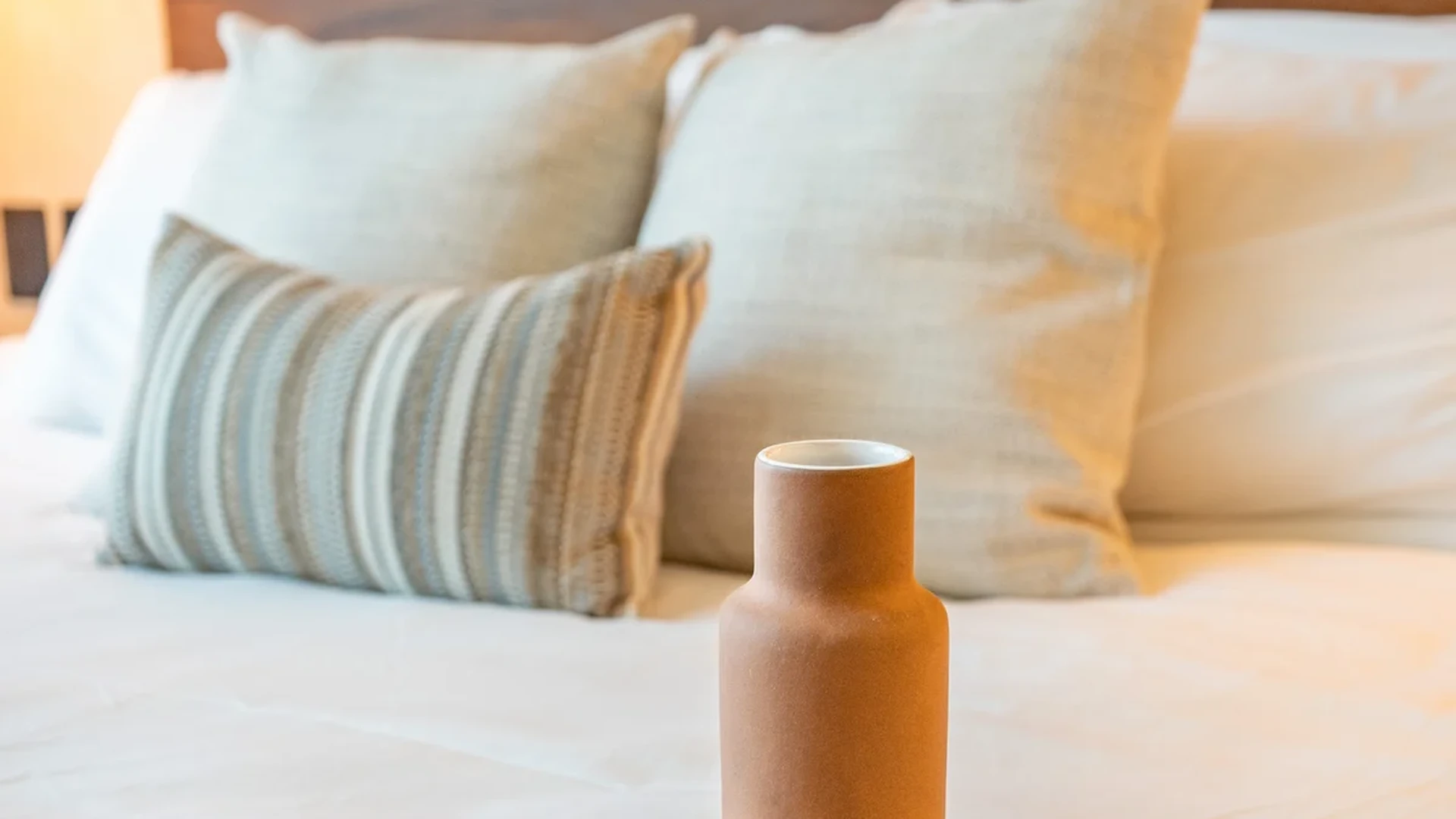 Image of a Comfortable Bedroom, featuring Wooden Headboard and Boho-Chic Decor.