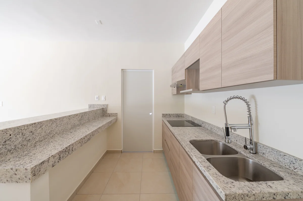 View of Modern Kitchen at Selva Escondida II, showcasing Granite Countertops, Light Wood Cabinets.