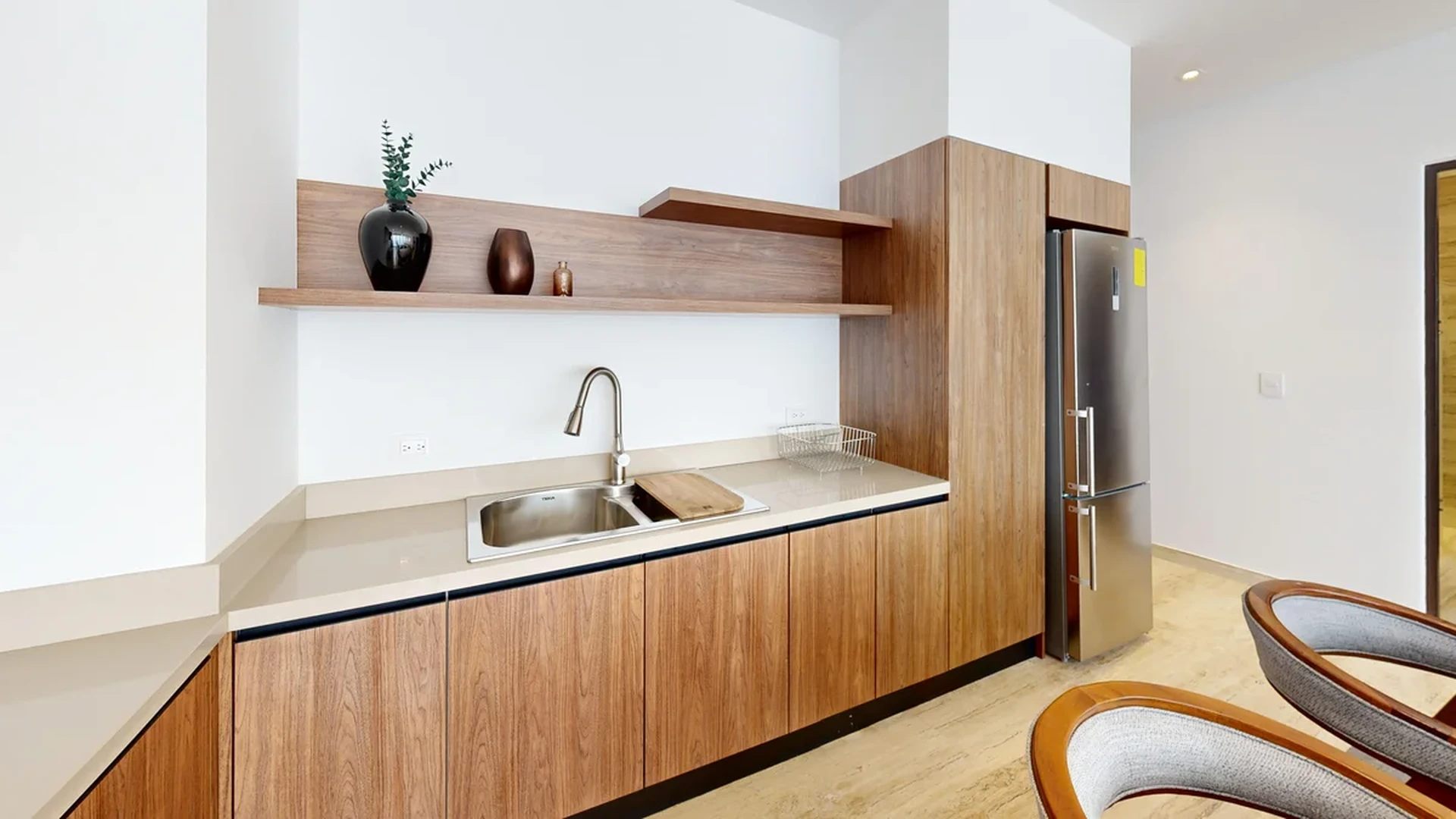 View of Modern Kitchenette at Ceiba at 25, showcasing Wood Cabinetry, Stainless Steel Appliances.