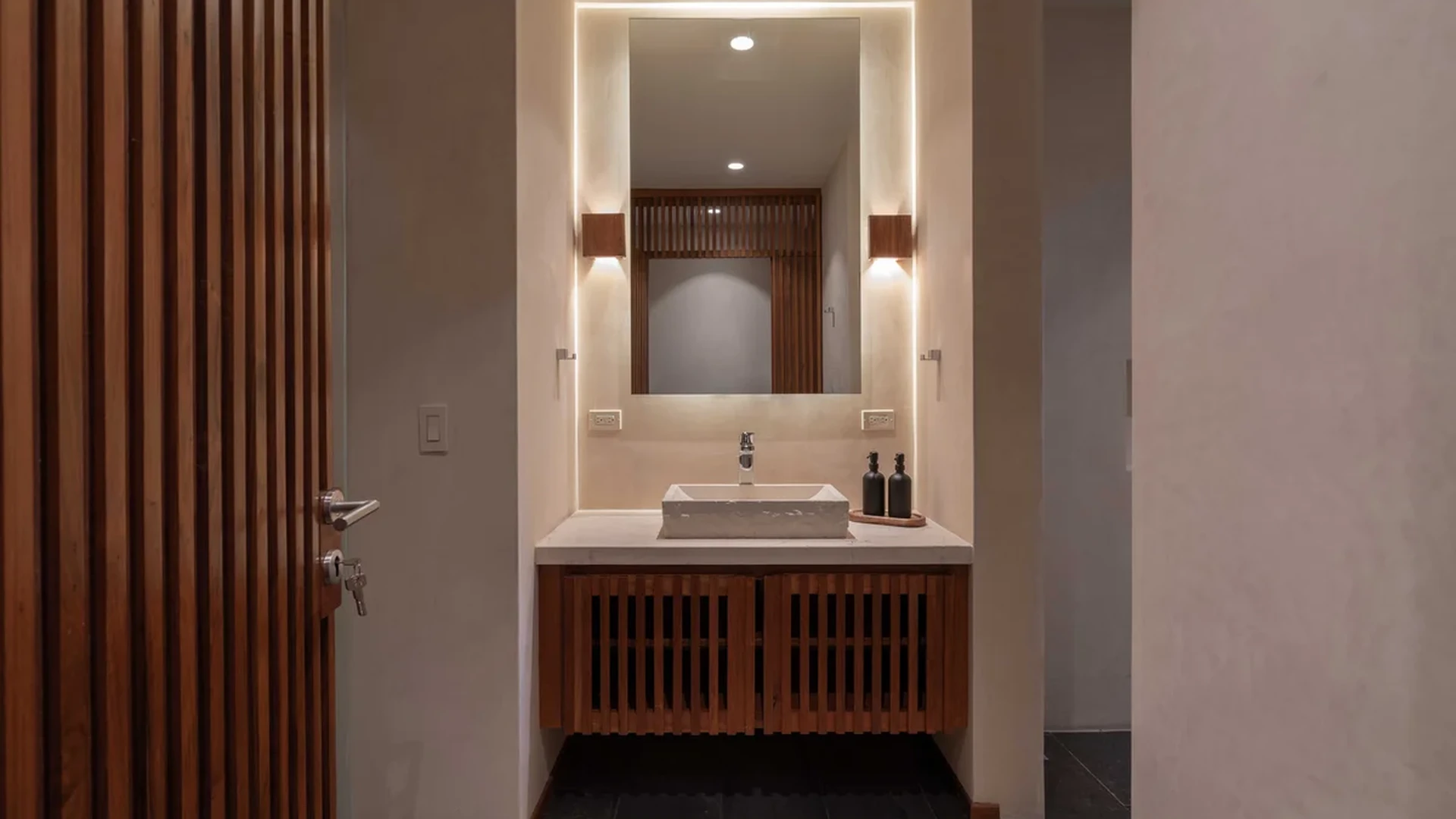 View of Modern Bathroom at Miraluna, showcasing Designer Vanity, Backlit Mirror.