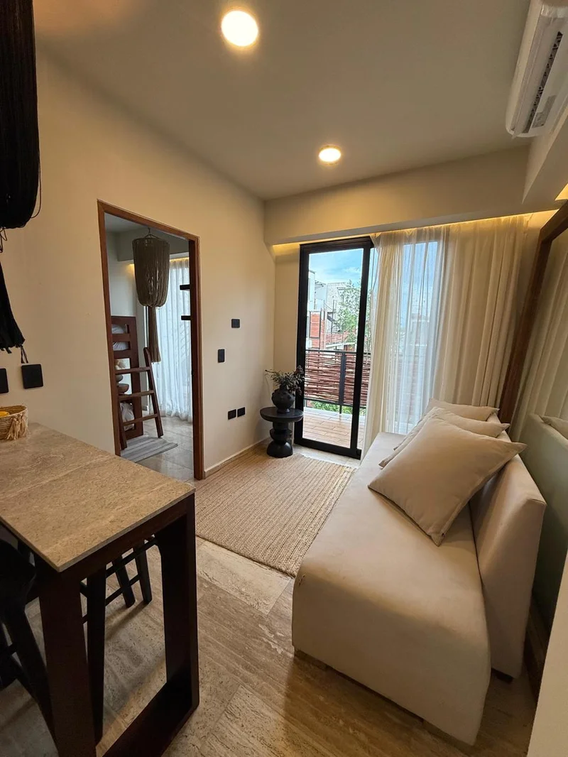 View of Modern Living Room at Naia Naay, showcasing Compact Apartment, Neutral Decor.