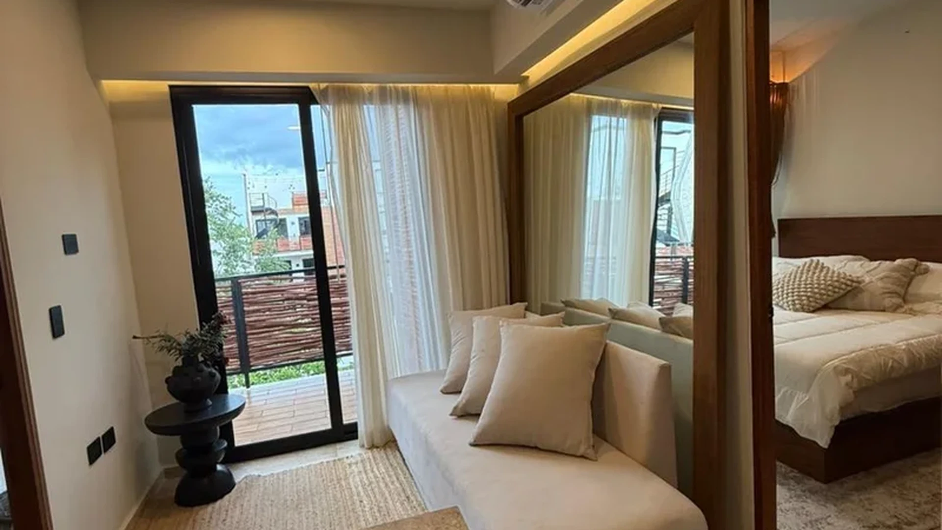 View of Modern Apartment at Naia Naay, showcasing Living Area, Bedroom Reflection.