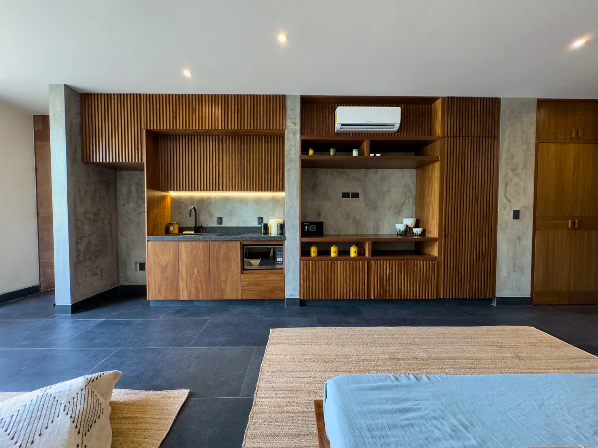 View of Studio Apartment at Mestiza 15, showcasing Modern Kitchenette, Wood Slat Wall.