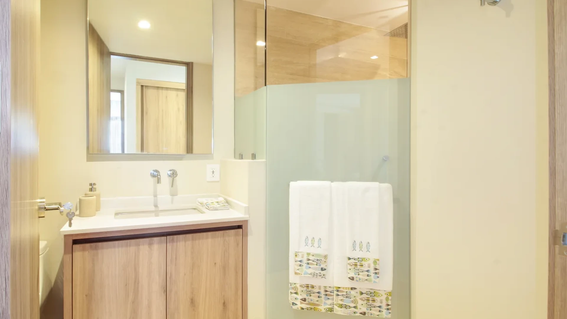 View of Modern Bathroom at Hodela, showcasing Wood Vanity, Glass Shower.