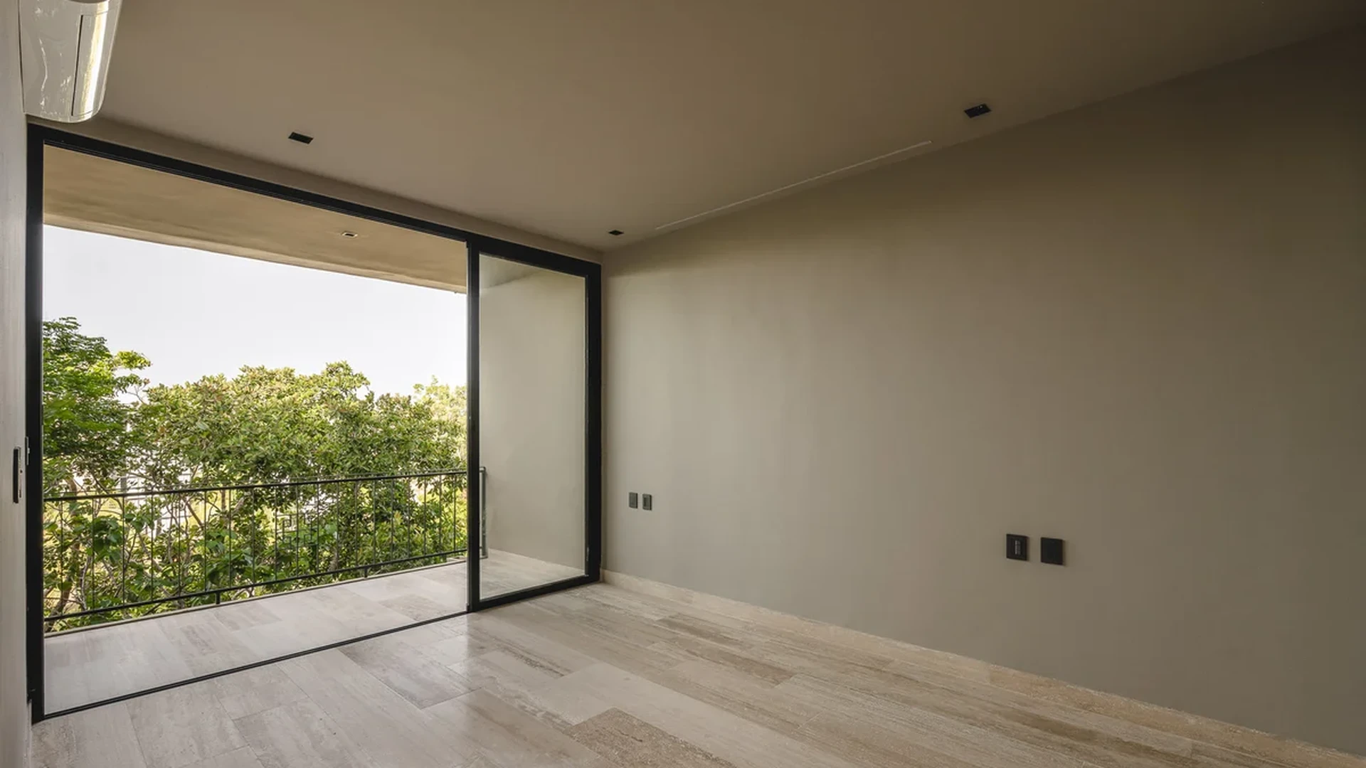 View of Spacious Bedroom at Arthouse, showcasing Private Balcony, Travertine Flooring.
