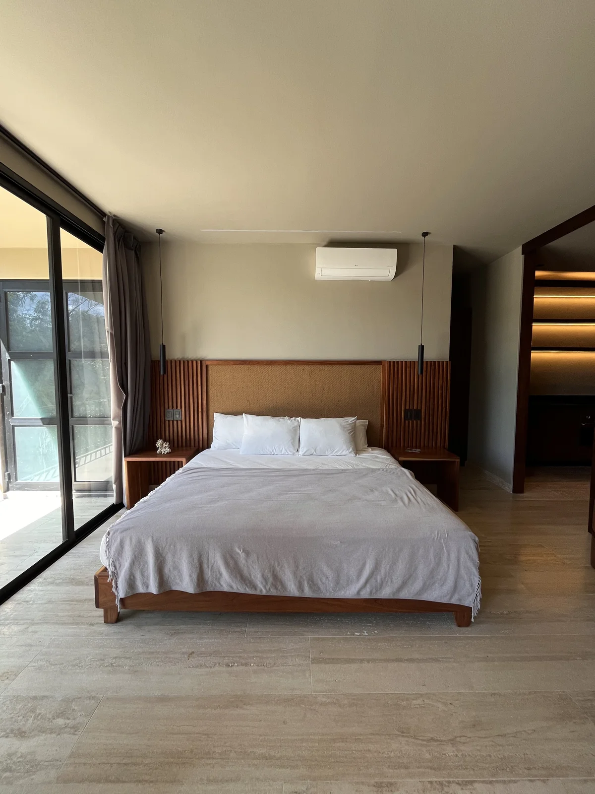 View of Modern Bedroom at Arthouse, showcasing Wooden Headboard, Natural Light.