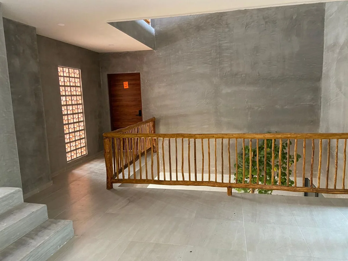 View of Modern Interior at Hoja Santa, showcasing Concrete Walls, Rustic Railing.