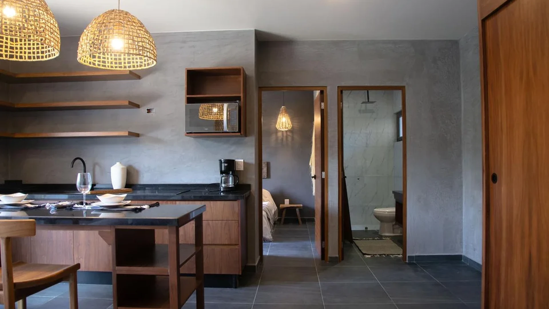 View of Studio Apartment at Hoja Santa, showcasing Modern Kitchenette, Concrete Walls.