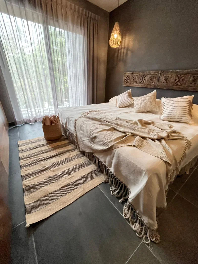 View of Bedroom at Hoja Santa, showcasing Bohemian Decor, Dark Accent Wall.