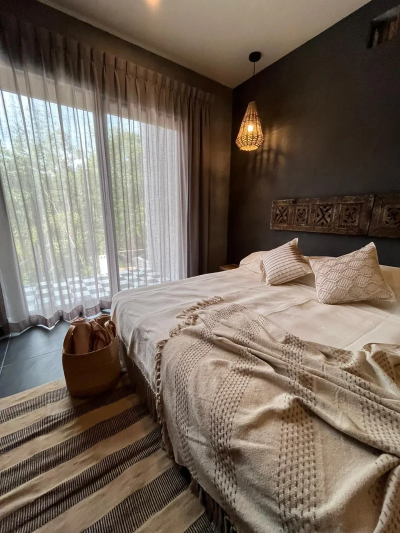 View of Bedroom Interior at Hoja Santa, showcasing Modern Bohemian Style, Dark Accent Wall.