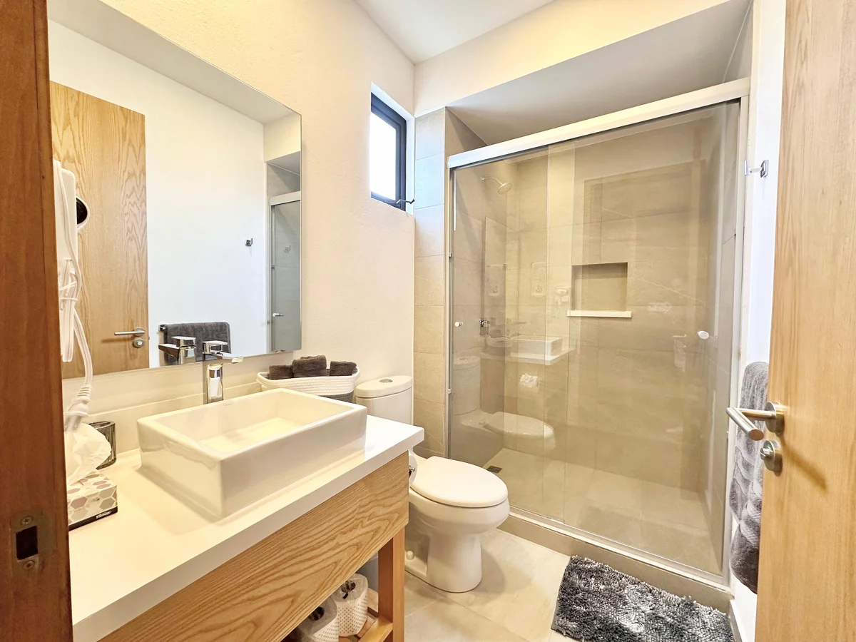 View of Modern Bathroom at Levitat 20, showcasing Glass Shower, Vessel Sink.