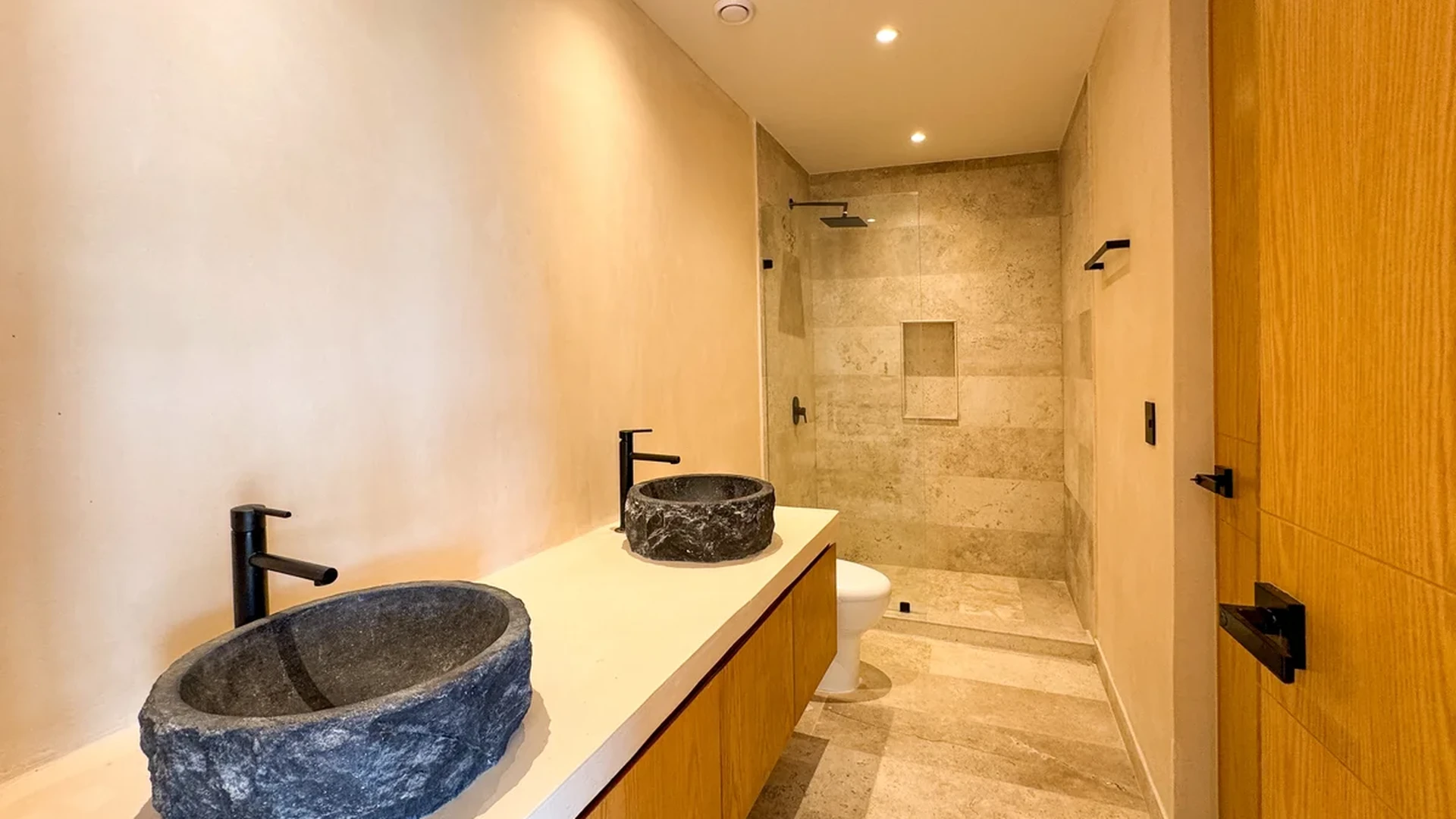 View of Modern Bathroom at Oniric, showcasing Stone Vessel Sinks, Walk-in Shower.