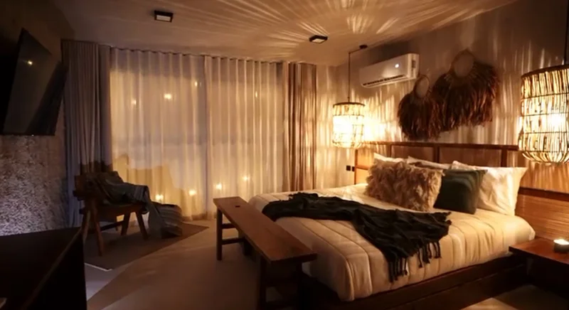 View of Bohemian Bedroom at Tamarindos, showcasing Rustic Decor, Mood Lighting.