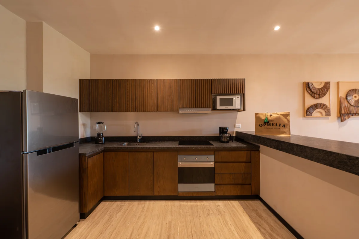 View of Modern Kitchen at Ophelia, showcasing Wood Cabinetry, Stainless Steel Appliances.