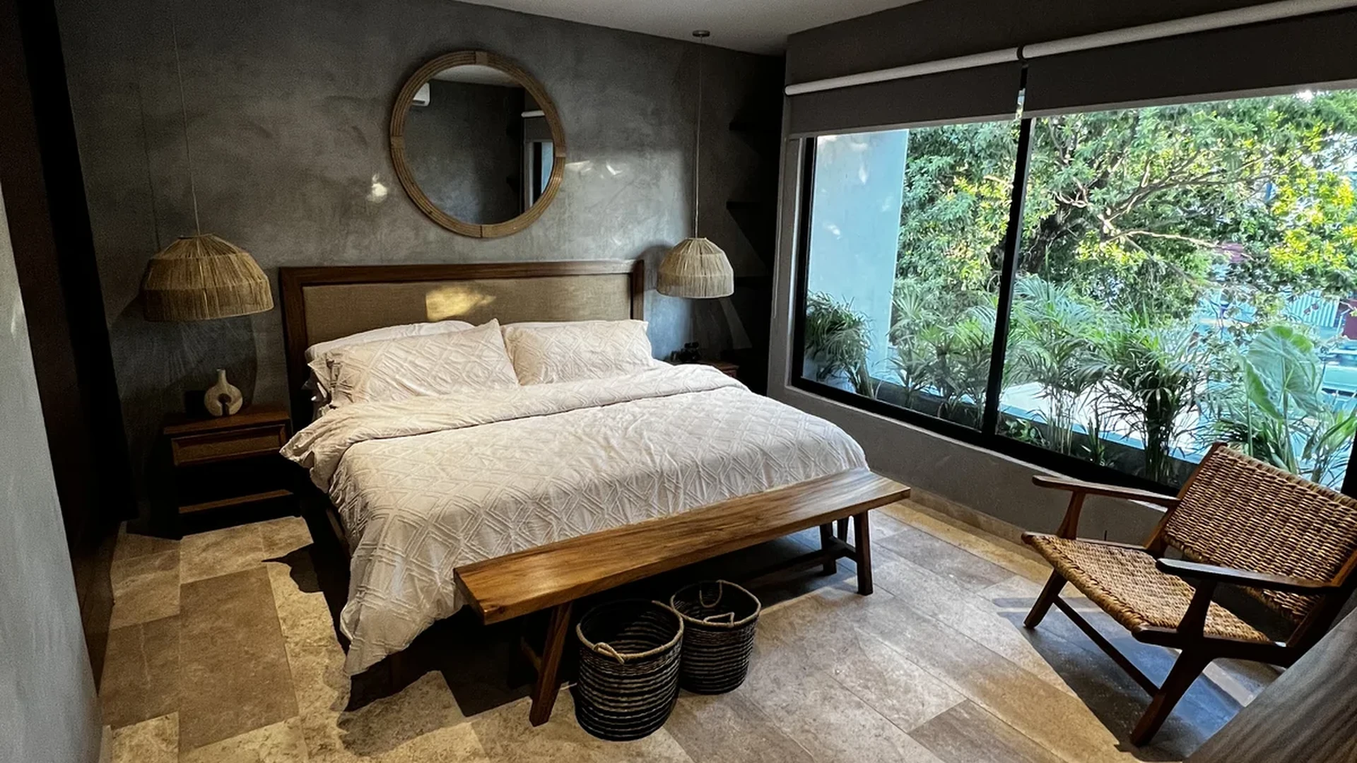 Image of a Master Bedroom, featuring Stone Tile Flooring and Concrete Accent Wall.