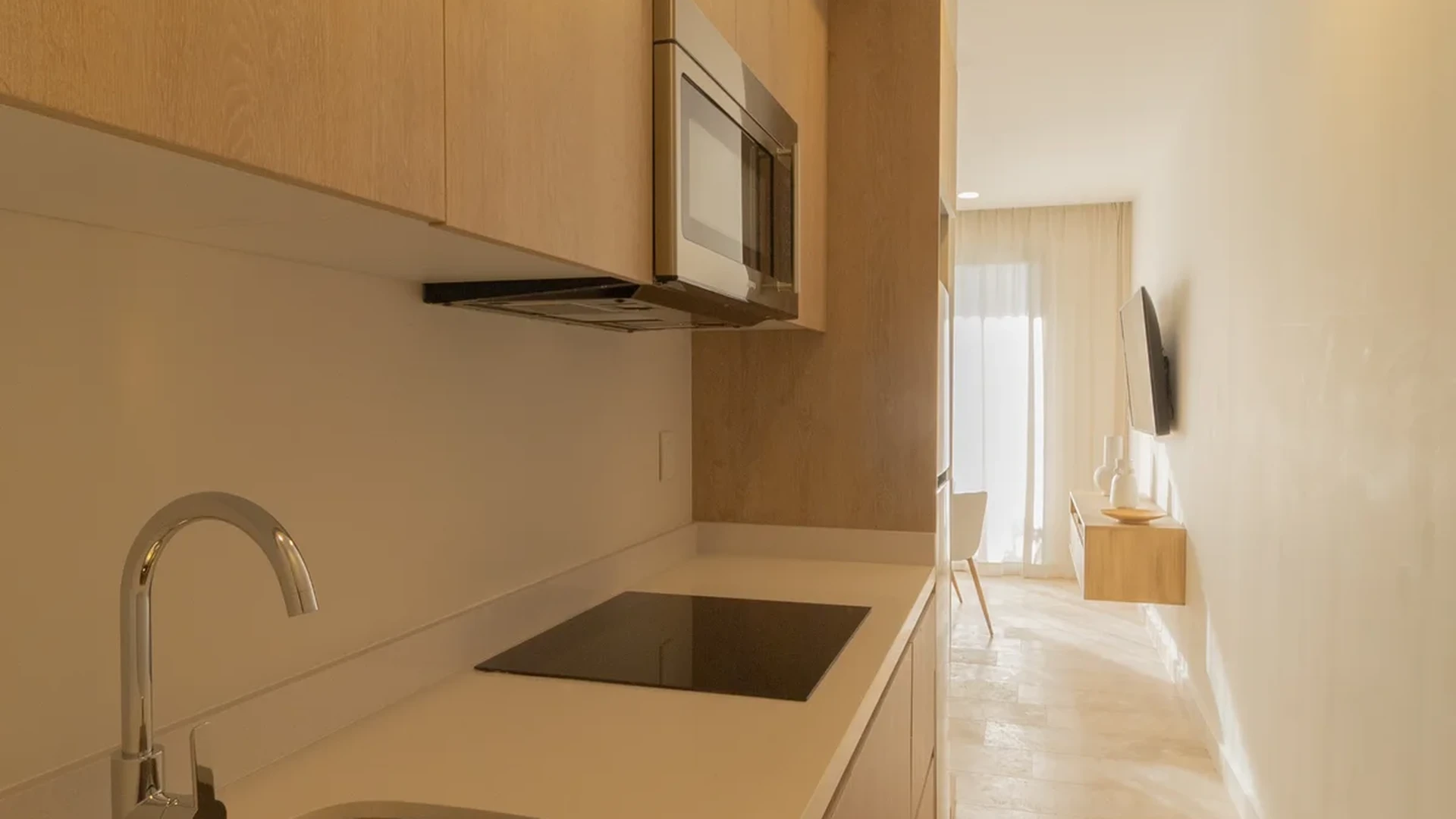View of Kitchenette at Vibbe, showcasing Modern Apartment, Light Wood Cabinetry.