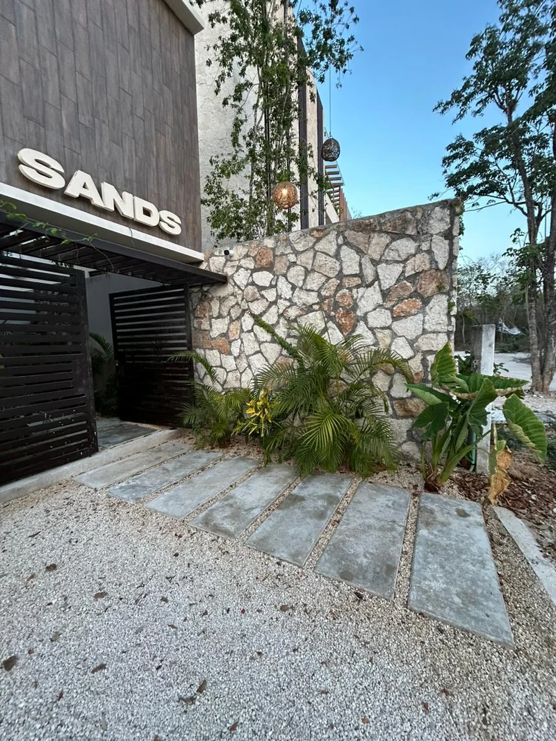 View of Modern Entrance at Sands Tulum, showcasing Building Facade, Stone Accent Wall.