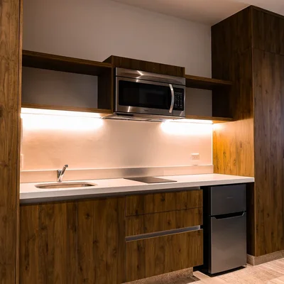 View of Modern Kitchenette at Duna, showcasing Compact Kitchen Design, Wood Grain Cabinetry.