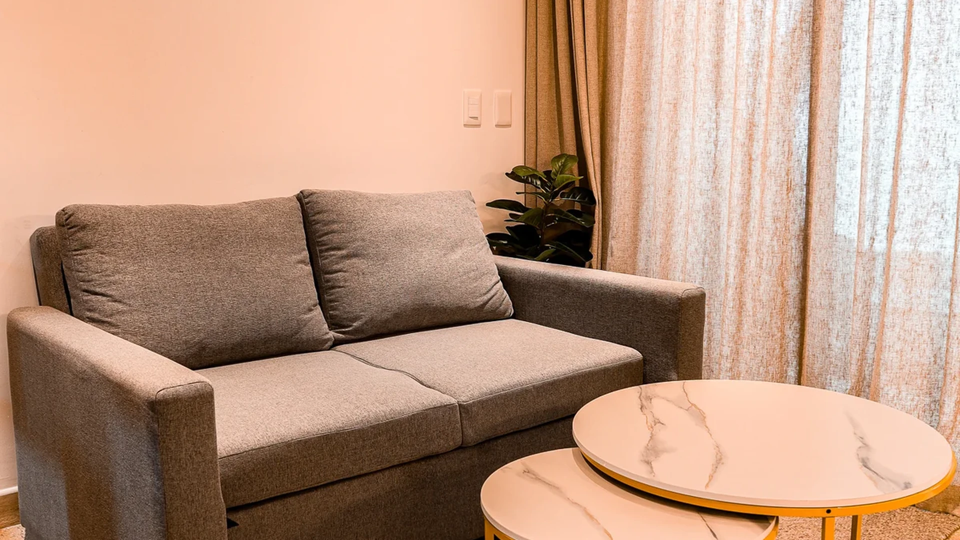 View of Modern Living Area at Duna, showcasing Cozy Sofa, Nesting Coffee Tables.