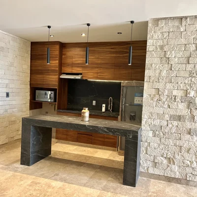 View of Modern Kitchen at Amaru, showcasing Kitchen Island, Stone Accent Wall.